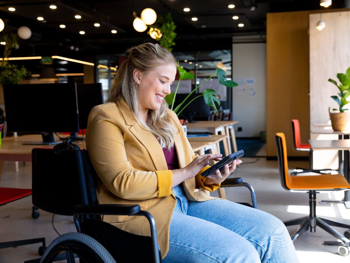 Geschäftsfrau im Rollstuhl mit Tablet im Büro